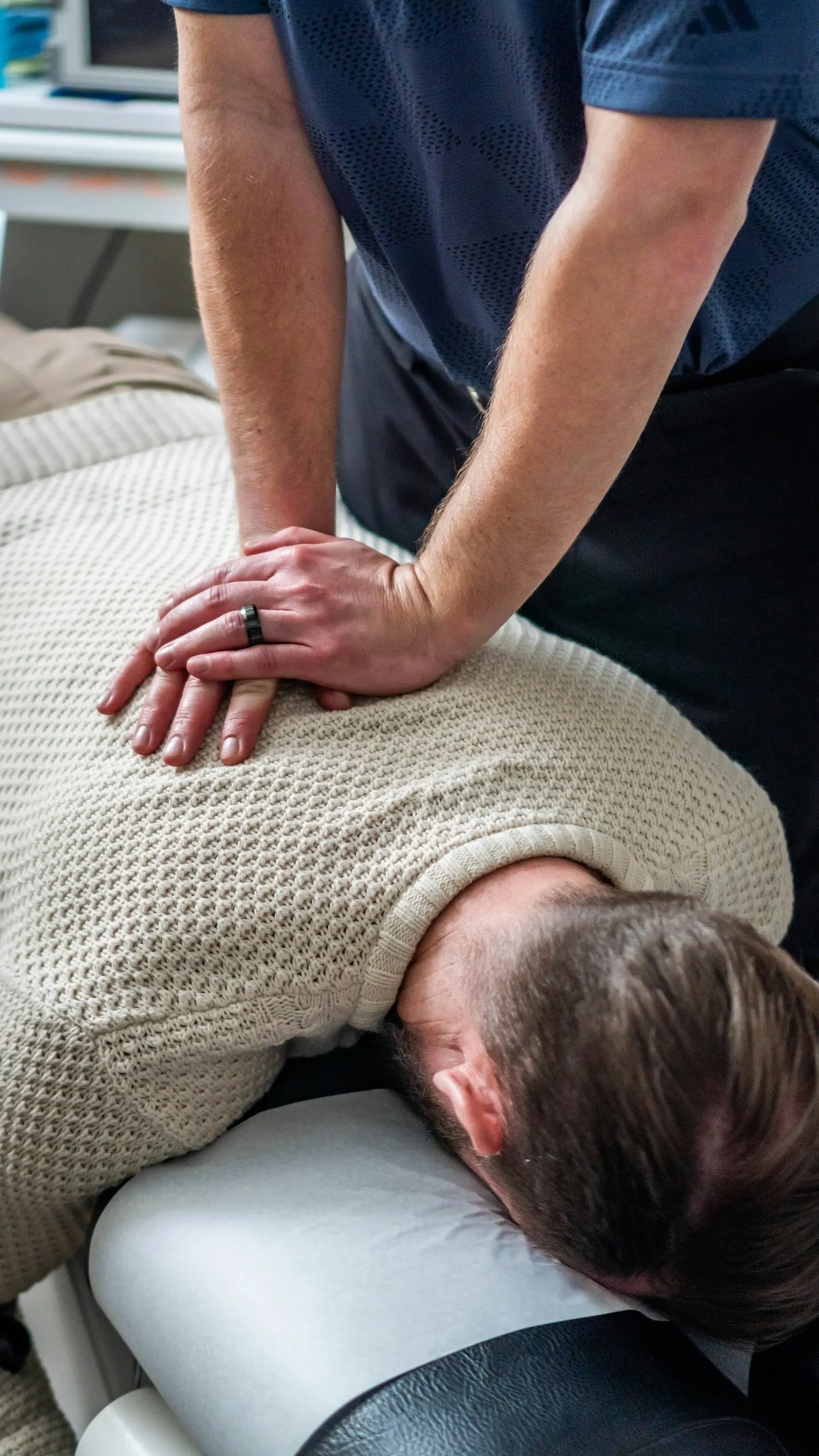Therapeutin behandelt den Rücken eines Patienten